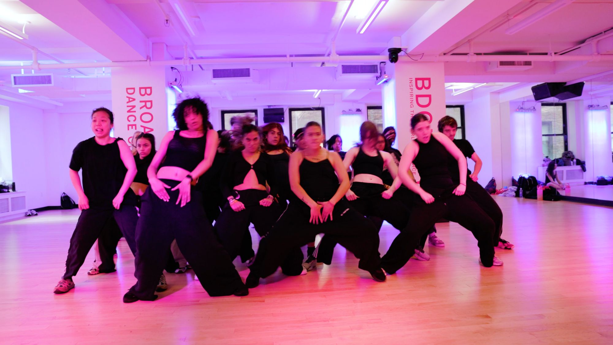 The whole class in formation at Broadway Dance Center, everyone low in the same shape on the same count