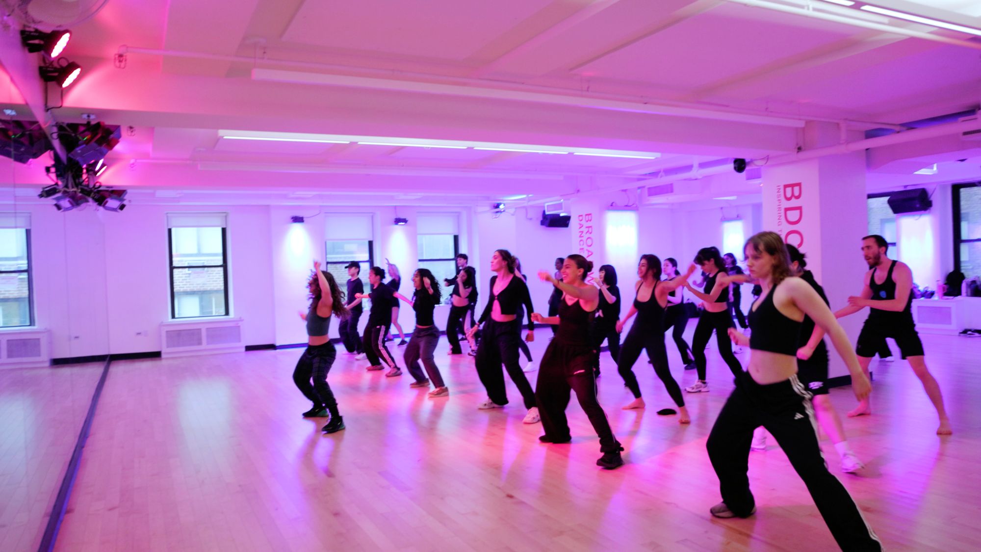A full class crossing the floor in lines at Broadway Dance Center, Galit leading on the left