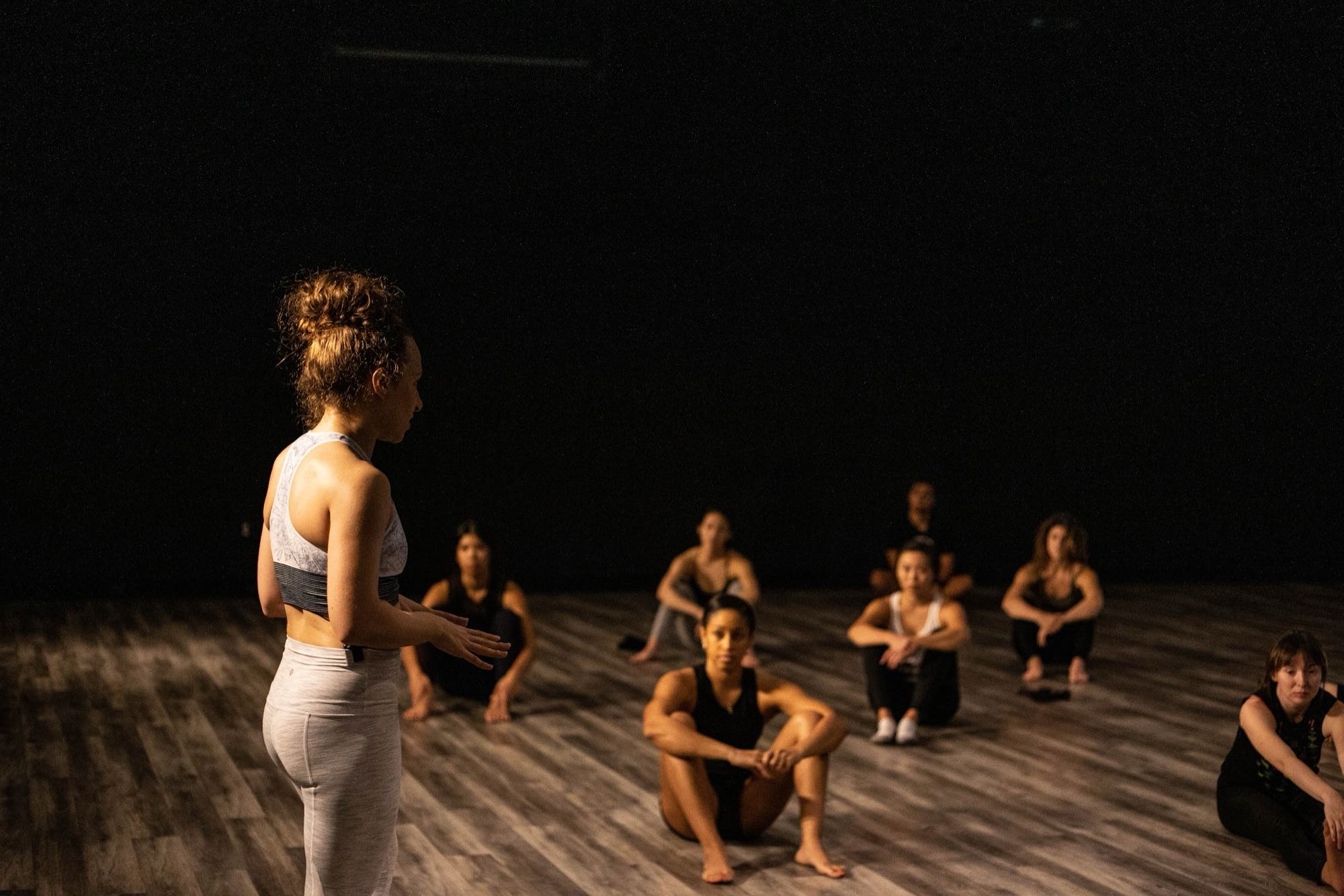 Galit standing at the front of a seated room at Movement Lifestyle, the group watching her