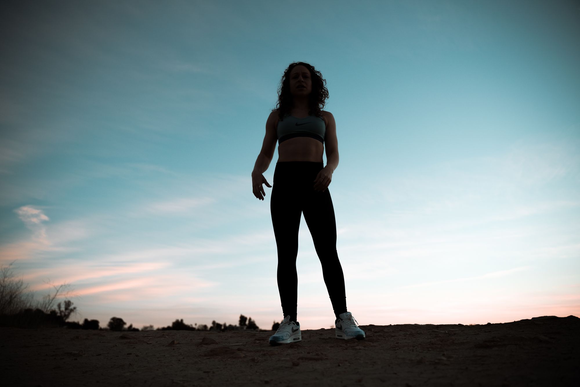 Galit standing in silhouette against a dusk sky above Los Angeles