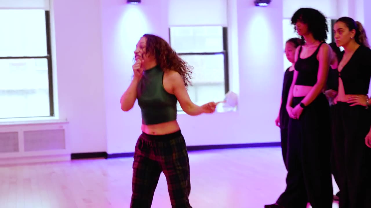Galit Friedlander laughing with her class at Broadway Dance Center under magenta stage light