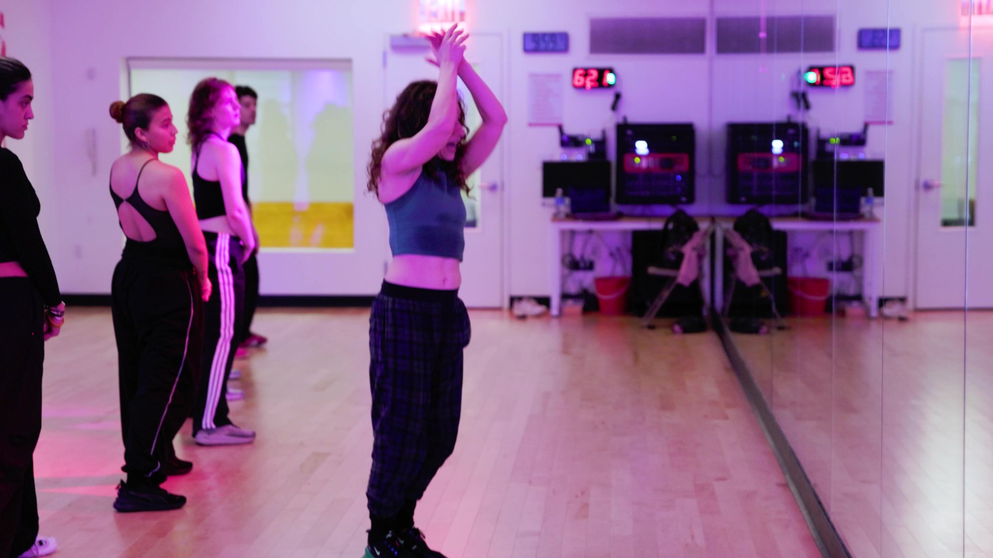 A dancer with both arms raised in the middle of a class at Broadway Dance Center