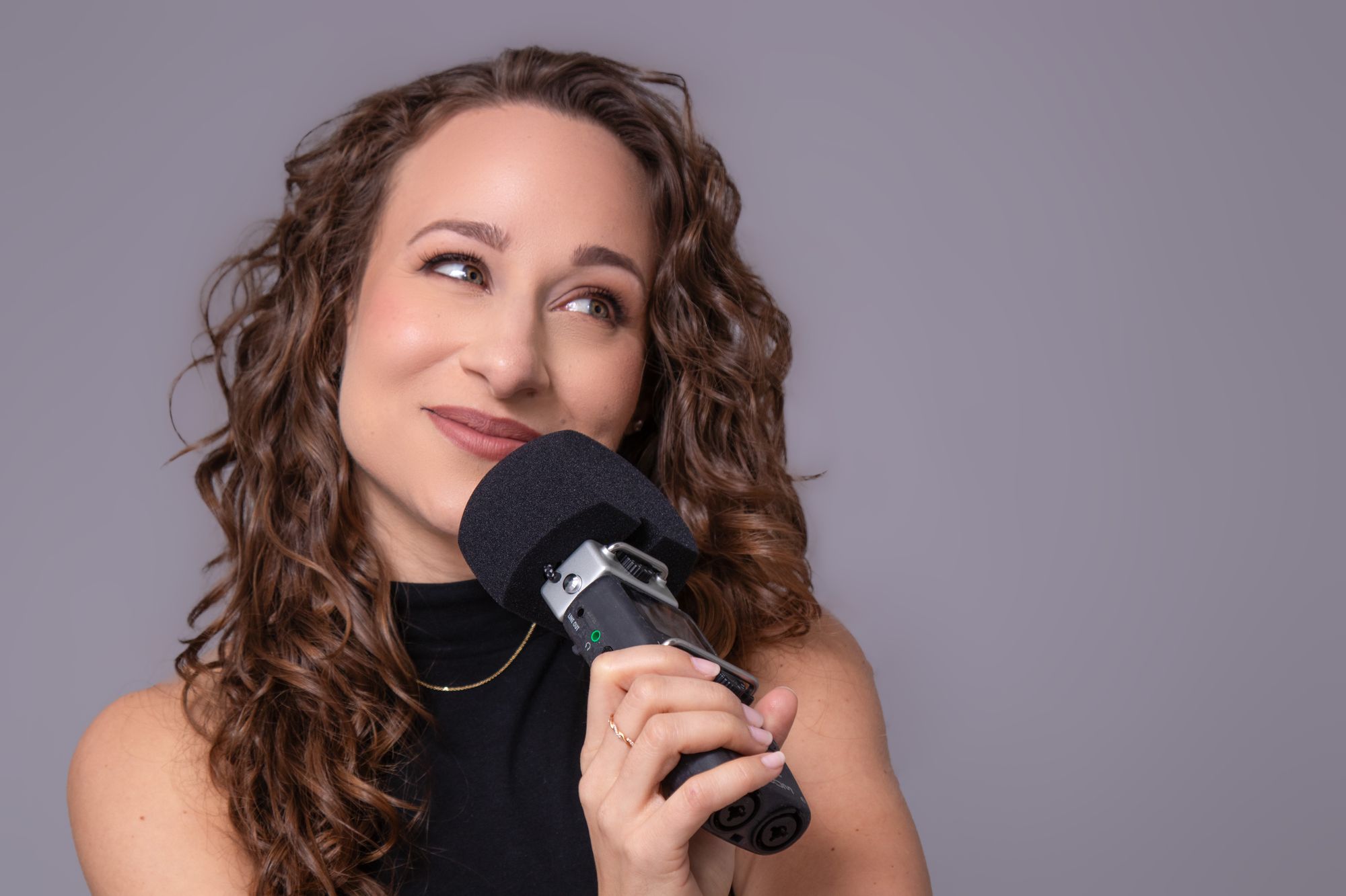 Galit close to a microphone, mid interview